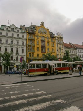 Eski bir tramvay kafenin arka planında önü açık balkonları ve karşı taraftaki sıva ile farklı renklerde eski binaların manzarası