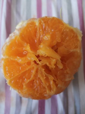 Yarım portakal kabuğu açık renkli bir kumaşın üzerinde yatıyor.