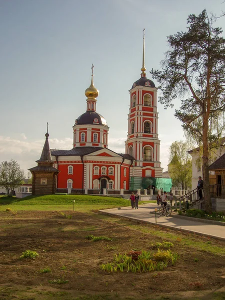 空の芝生と青空に対して木製の礼拝堂と赤と白の鐘楼と古い教会の眺め — ストック写真