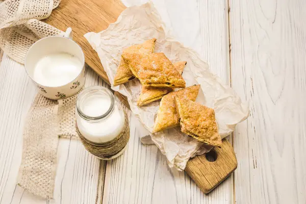 Homemade puff pastry cookies, on an original wooden board,  in a light key
