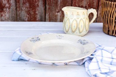 Tahta bir masada eski boş bir porselen tabak, köyde piknik.