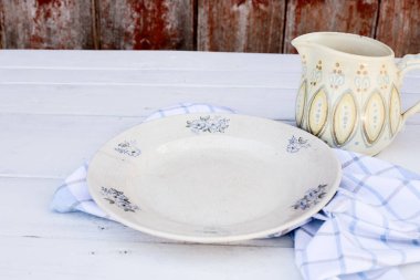 Tahta bir masada eski boş bir porselen tabak, köyde piknik.