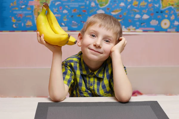 Smiling child holding a bunch of bananas, the CONCEPT of CHILDREN and FRUIT