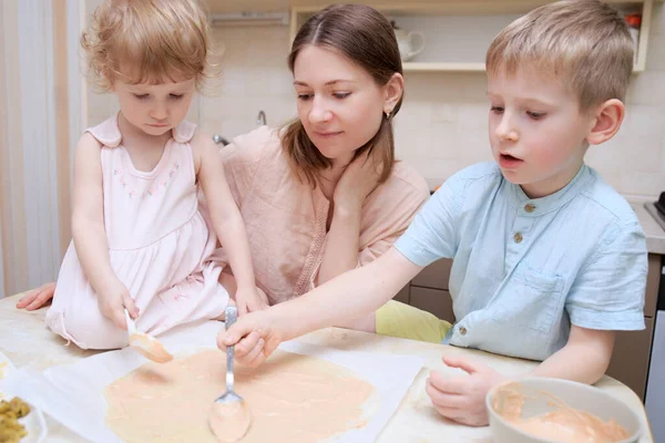 happy mom cooks pizza with her kids at home, lifestyle people