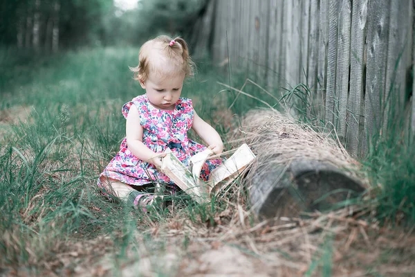 Mała Piękna Dziewczynka Czytająca Książkę Siedzącą Trawie Dzieci Czytanie — Zdjęcie stockowe