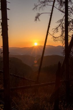 Sonbahar zamanı, dağların arasından gün doğar.