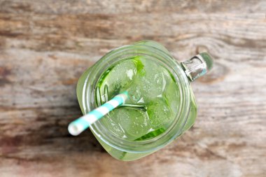 Mason kavanoza salatalığın üzerinde ahşap masa ile taze limonata