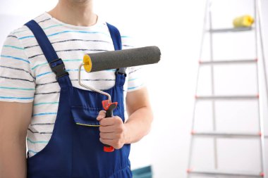 Oda boya silindiri ile genç dekoratör