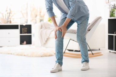 Genç adam evde diz ağrısı acı
