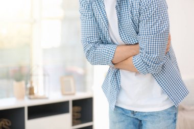 Genç adam evde mide ağrısı çekiyor.