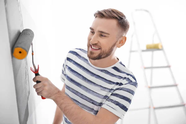 Young man painting wall in room — Stock Photo, Image
