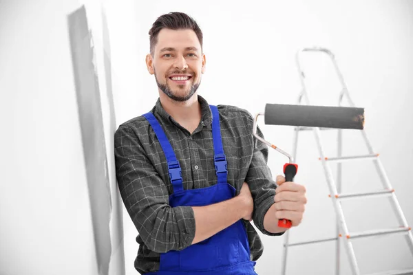 Joven decorador masculino pintura de pared en la habitación — Foto de Stock