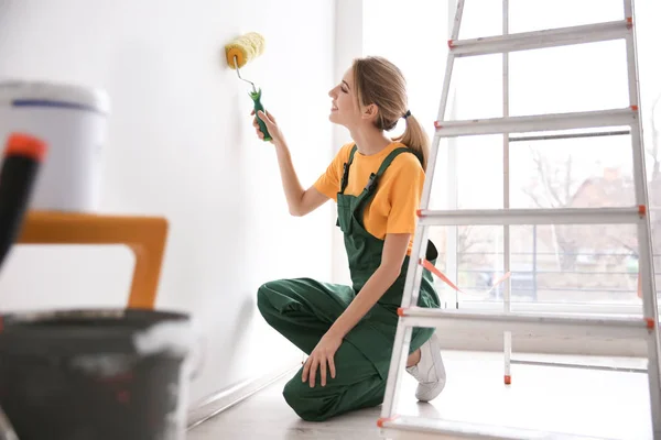 Jovem parede de pintura decorador feminino no quarto — Fotografia de Stock