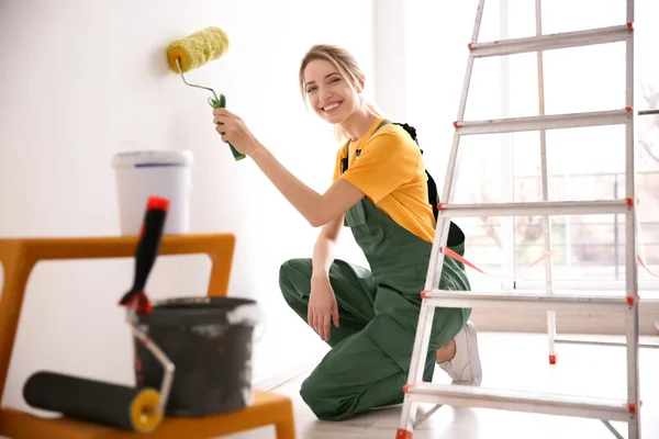 Jovem parede de pintura decorador feminino no quarto — Fotografia de Stock