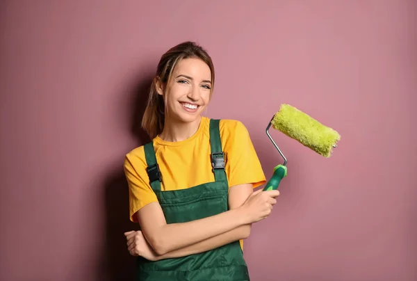 Young female decorator with paint roller near color wall — Stock Photo, Image