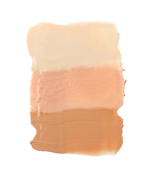 Diferentes tonos de base líquida sobre fondo blanco. Productos de maquillaje profesional — Foto de Stock