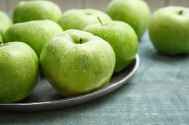 Ahşap masa, closeup üzerinde taze yeşil elma ile plaka