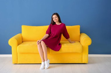 Kanepede oturan genç ve güzel bir kadın.