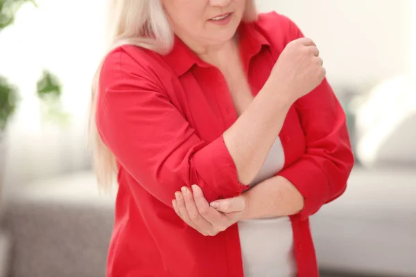 Mature woman suffering from elbow pain at home — Stock Photo, Image