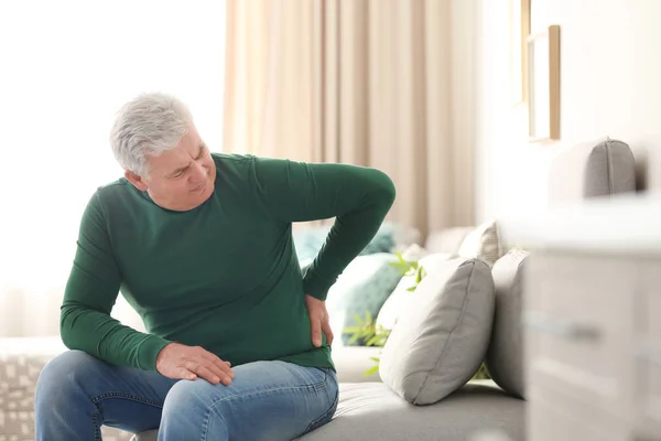 Mature man suffering from back pain at home — Stock Photo, Image