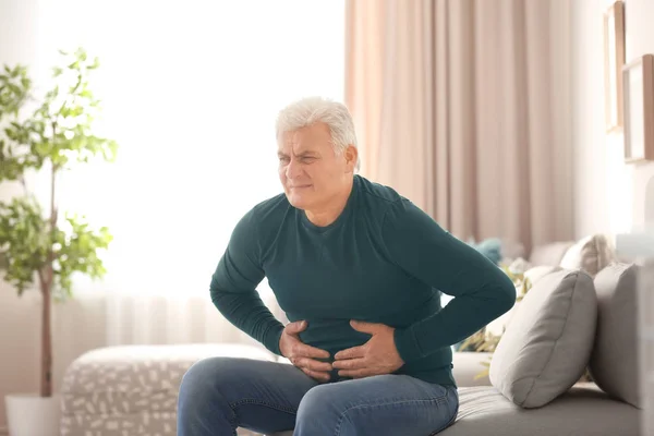 Hombre maduro que sufre de dolor de estómago en casa —  Fotos de Stock