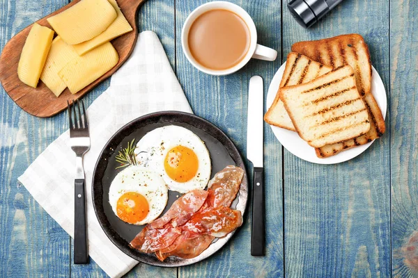 Composição com ovos fritos e bacon em fundo de madeira — Fotografia de Stock