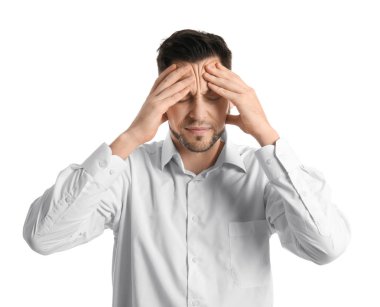 Beyaz arka planda baş ağrısı çeken genç bir adam.