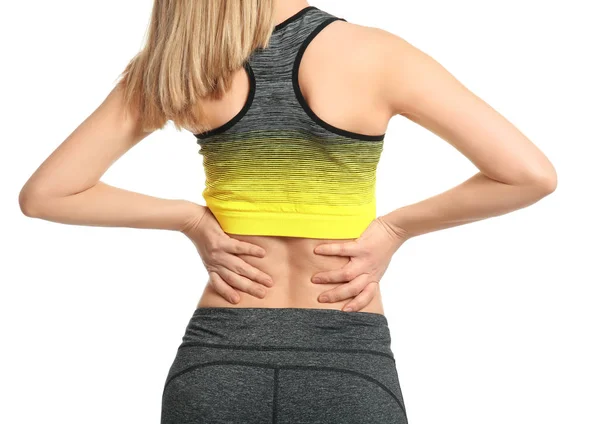 Mujer joven que sufre de dolor de espalda sobre fondo blanco —  Fotos de Stock