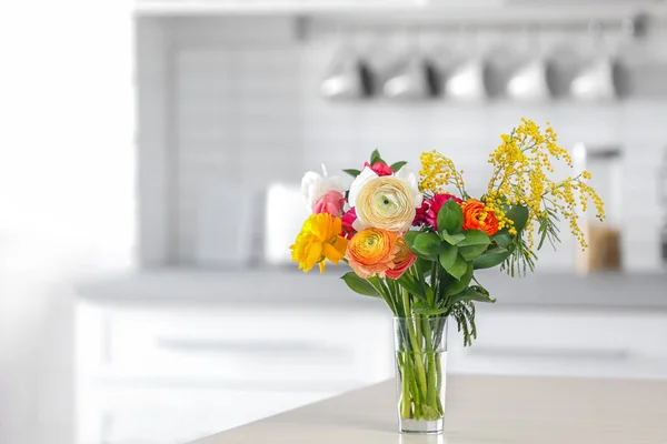 Ваза с красивыми цветами ранункула на столе в помещении — стоковое фото