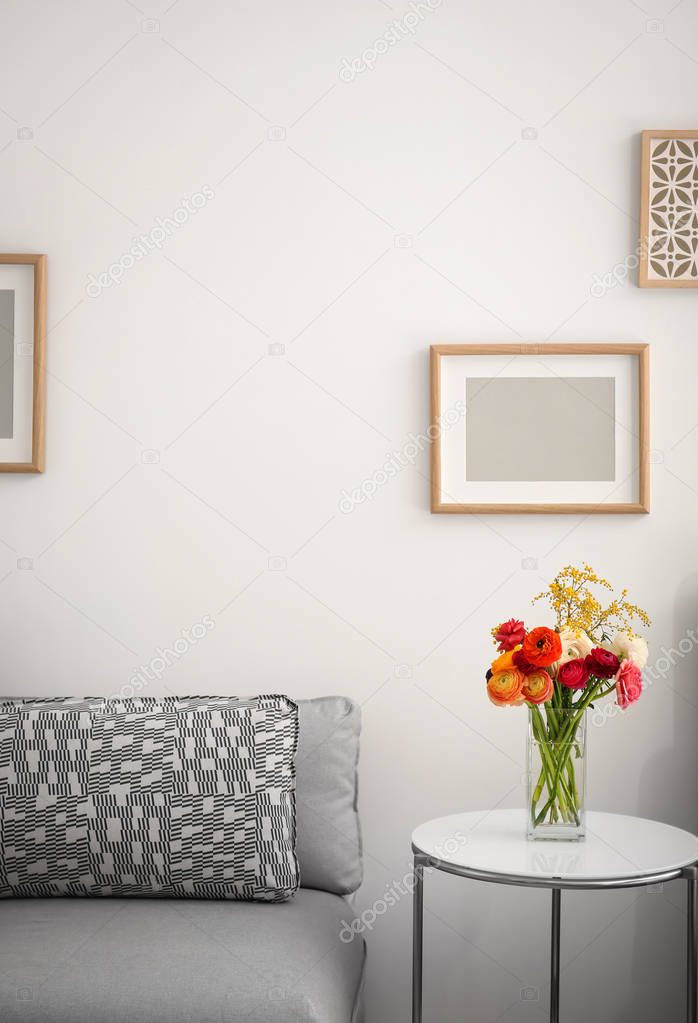 Elegant room interior with beautiful ranunculus and mimosa flowers