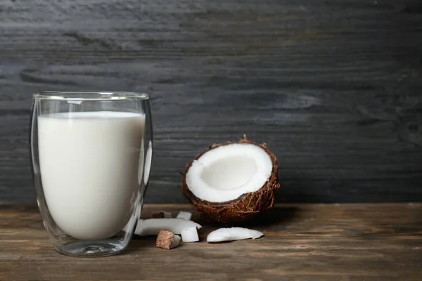 Vaso de leche de coco y nuez fresca sobre fondo de madera — Foto de Stock