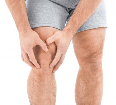 Beyaz arka planda diz ağrısı çeken bir adam.