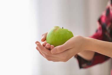 Olgun yeşil elma bulanık arka planda, closeup tutan kadın