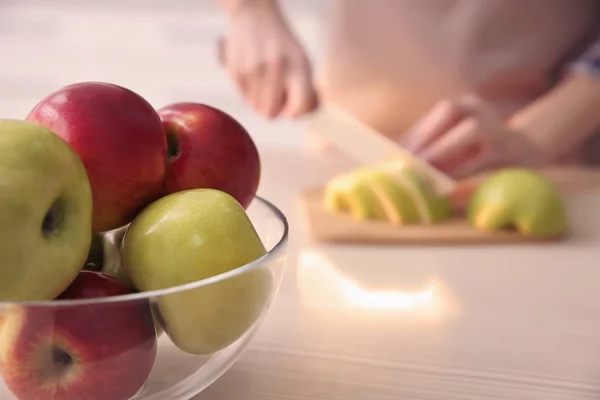 Kom met appels en wazig vrouw op achtergrond — Stockfoto