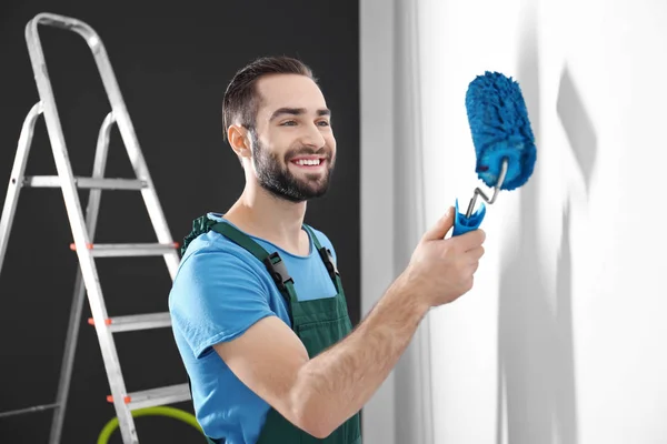 Parede de pintura decorador masculino com rolo dentro de casa — Fotografia de Stock