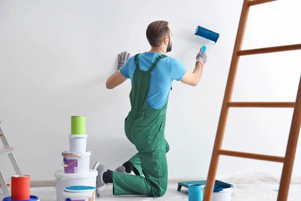 Mannelijke decorateur schilderen muur met roller binnenshuis — Stockfoto