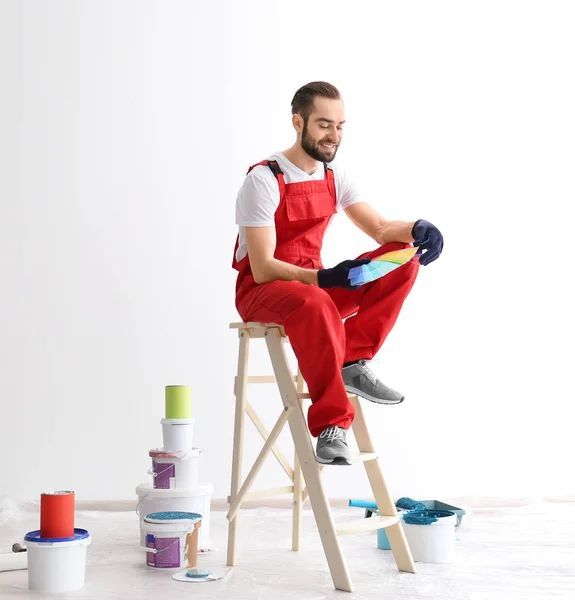 Decorador masculino sosteniendo muestras de paleta de colores en interiores —  Fotos de Stock