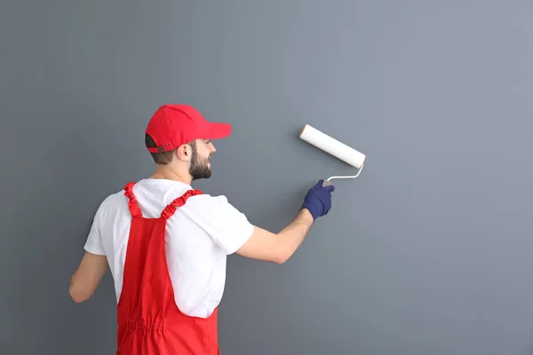 Parede de pintura decorador masculino com rolo no quarto — Fotografia de Stock