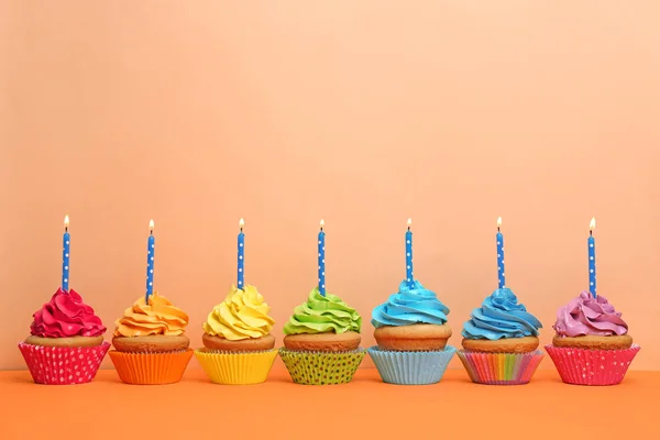 Geburtstag Cupcakes mit Kerzen auf farbigem Hintergrund — Stockfoto