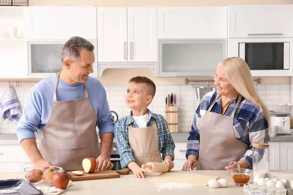 Šťastný starší pár s malým vnukem společné vaření v kuchyni — Stock fotografie