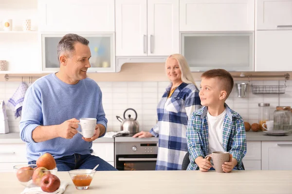 Felice coppia anziana che fa colazione con nipotino in cucina — Foto Stock