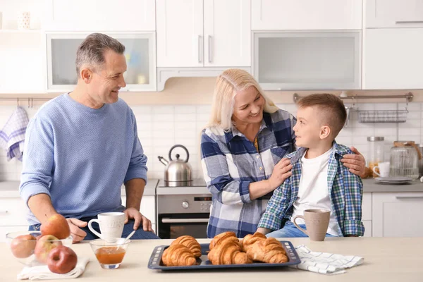 Felice coppia anziana che fa colazione con nipotino in cucina — Foto Stock