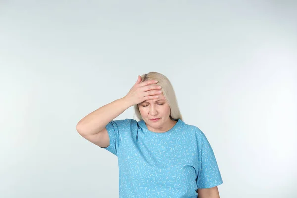 Woman suffering from headache on light background — Stock Photo, Image