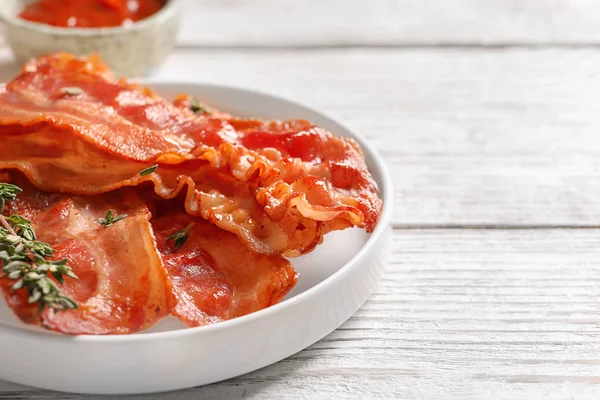 Placa con tocino frito en la mesa —  Fotos de Stock