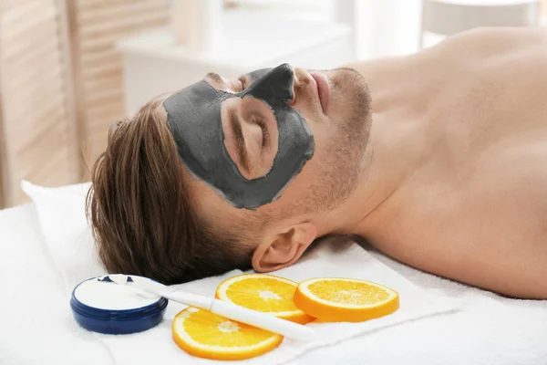 Uomo con maschera cosmetica nel salone spa — Foto Stock