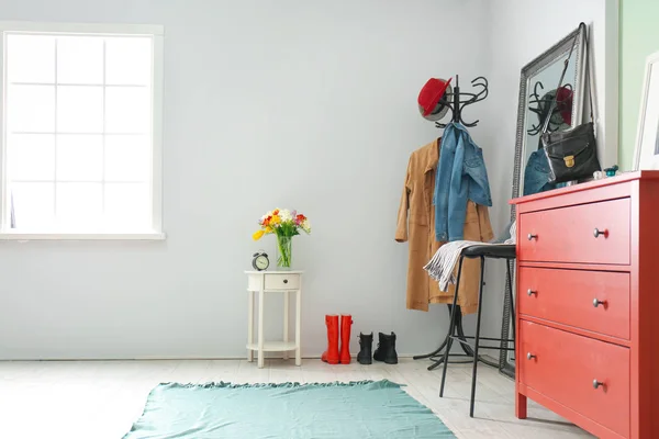 Interior de corredor moderno com roupas no suporte de cabide e espelho — Fotografia de Stock