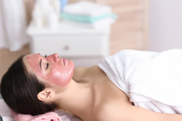 Giovane bella donna con maschera cosmetica nel salone spa — Foto Stock