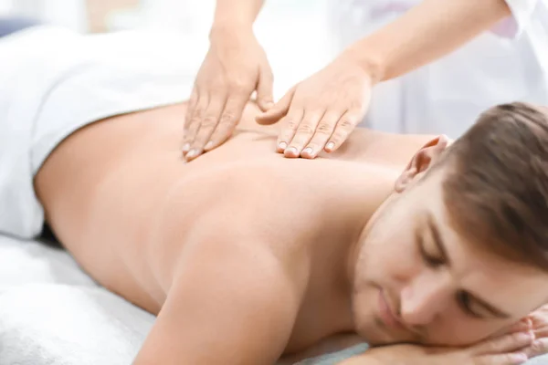 Młody człowiek mając masaż w salonie spa — Zdjęcie stockowe