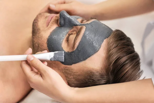 Człowiek o maski kosmetyczne w salonie spa — Zdjęcie stockowe