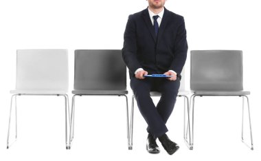 İş görüşmesi için beyaz arka plan üzerinde bekleyen genç adam